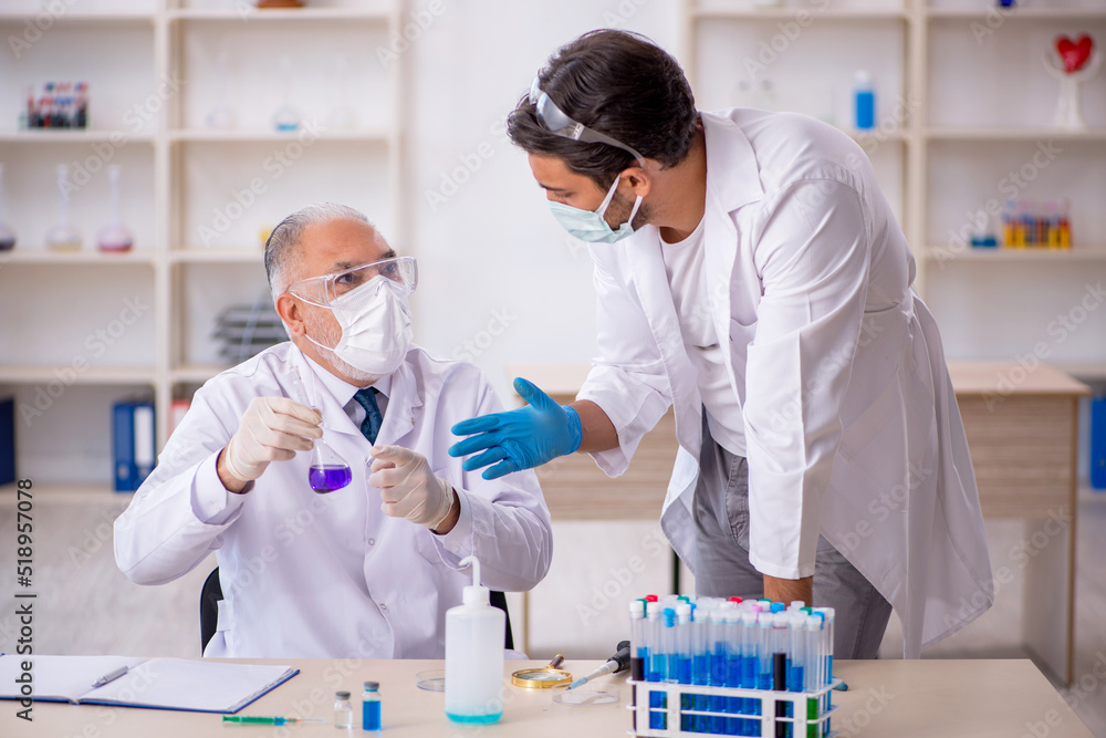 Two male chemist working at the lab Two male chemist working at the lab