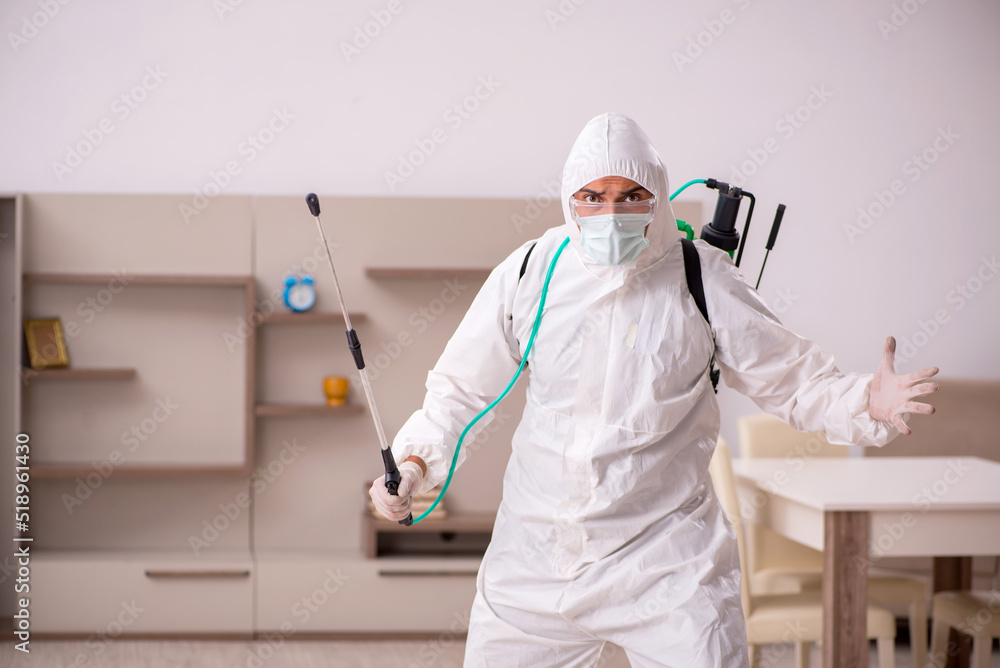 Fototapeta premium Young male contractor doing pest control at home