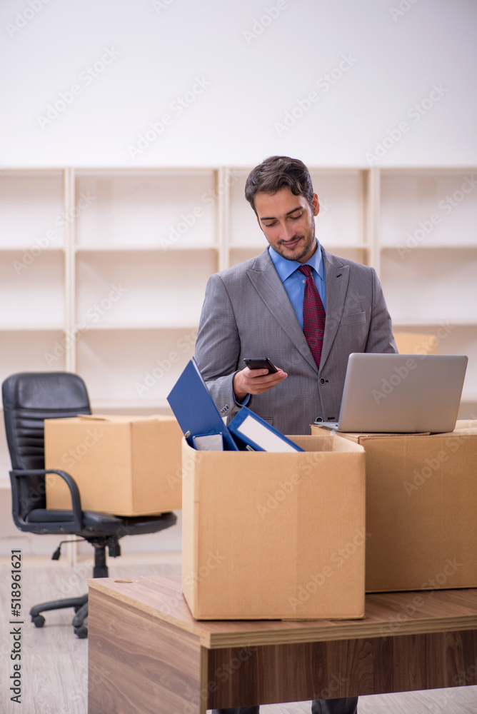 Young male employee in office relocation concept Young male employee in office relocation concept