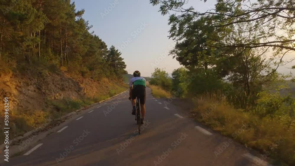 Triathlete cyclist Training on bicycle During Sunset.Cyclist Fitness Cycling Road Bike For Triathlon Race Recreation