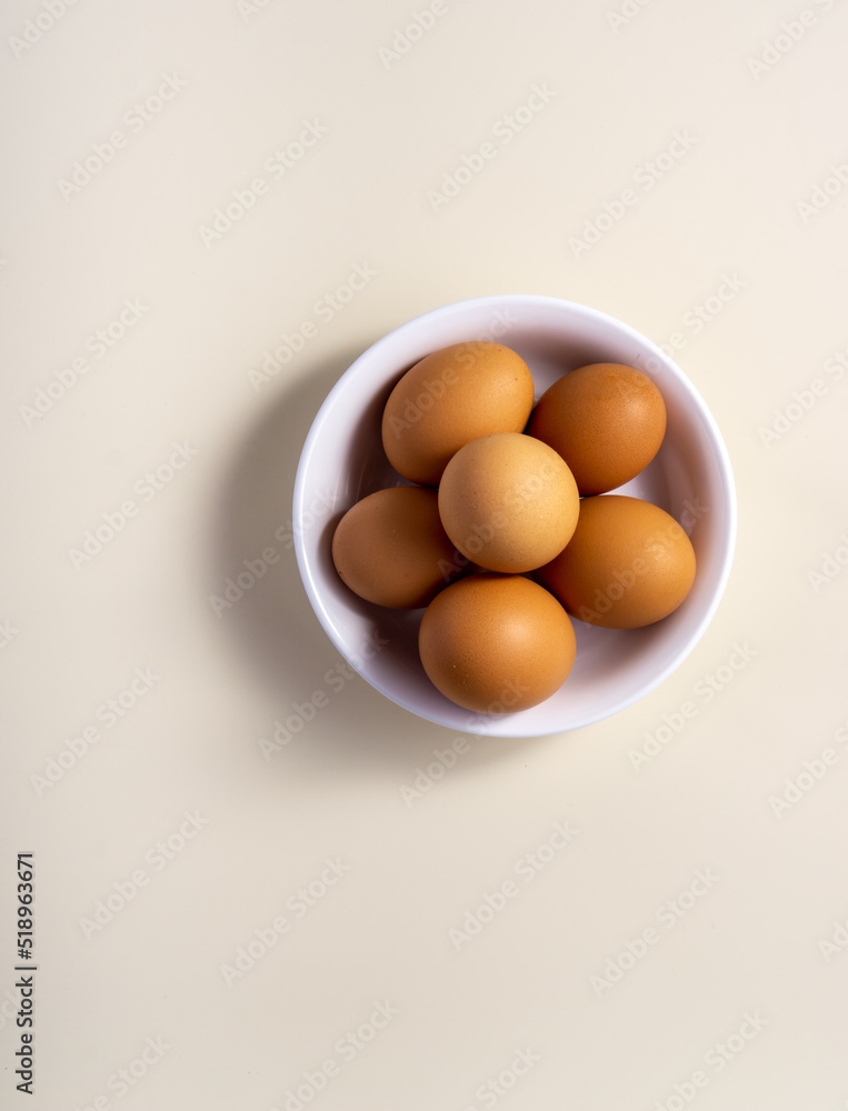 Whole raw egg in white bowl. Close up. Vertical. Broken White Background. Place for text.