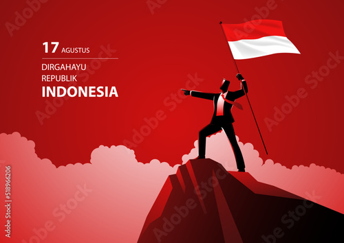 Businessman holding the flag of Indonesia on top of the mountain