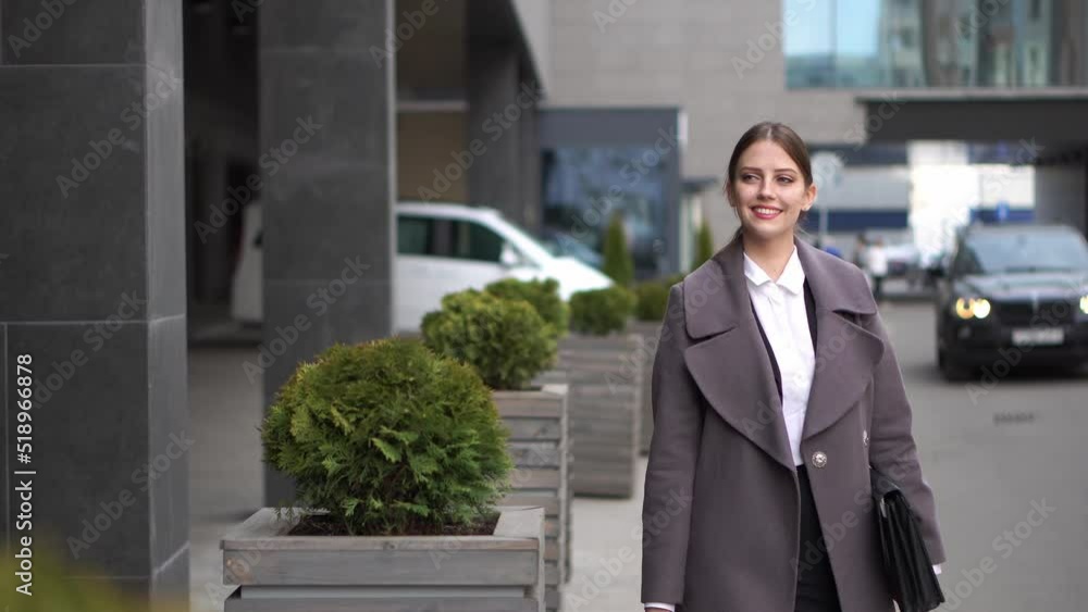 A woman in business clothes returns from a business meeting with documents A woman in business clothes returns from a business meeting with documents