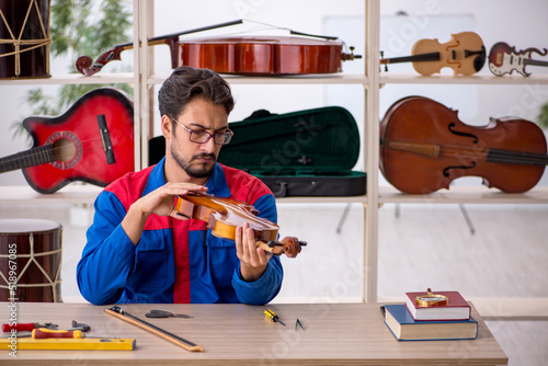Fotografie Young man repairing musical instruments at workshop