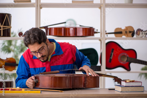 Obraz na płótnie Young man repairing musical instruments at workshop