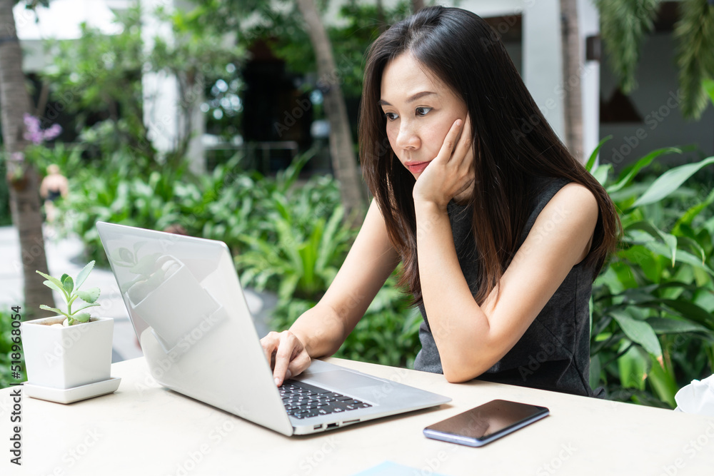 Young Asian businesswoman is working on laptop computer. Work from home, business and technology concept. Young Asian businesswoman is working on laptop computer. Work from home, business and technology concept.