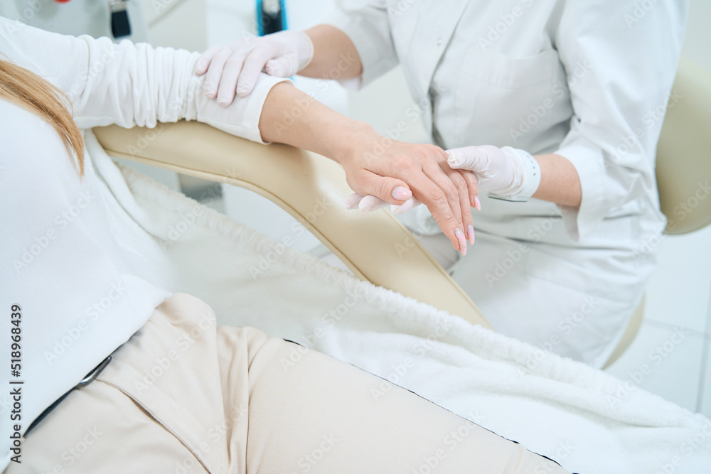 Dermatologist examines the skin of the patient hand Dermatologist examines the skin of the patient hand
