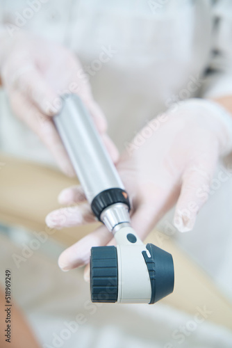 Dermatologist holding a dermoscope in his hands