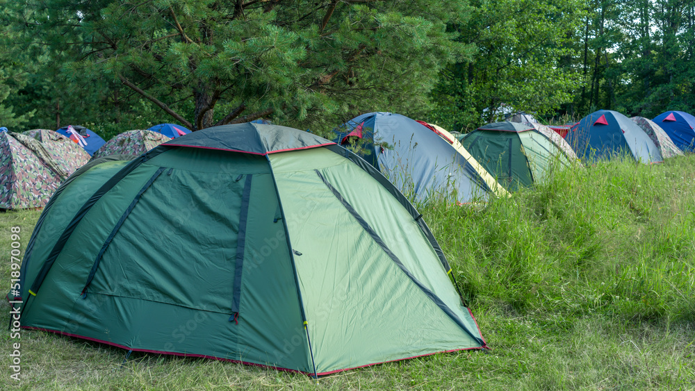 Tents camping area. Camping and tent. Tourist tents stands under the tree. Travel and adventure concepts.