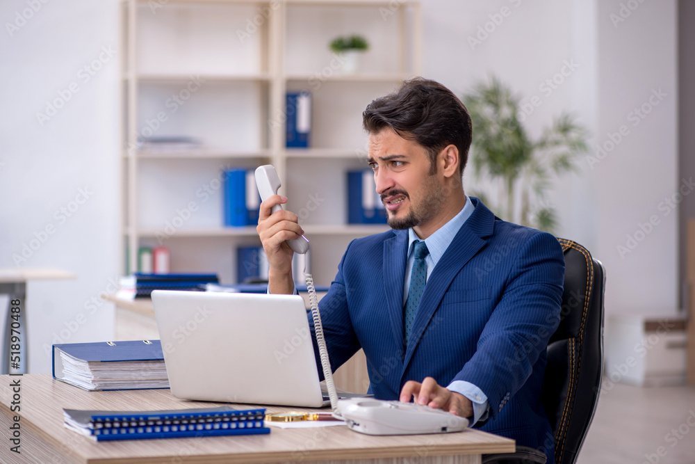 Young male employee working in the office Young male employee working in the office