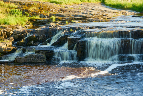 Waterfall in the mountains on the river among the forest.