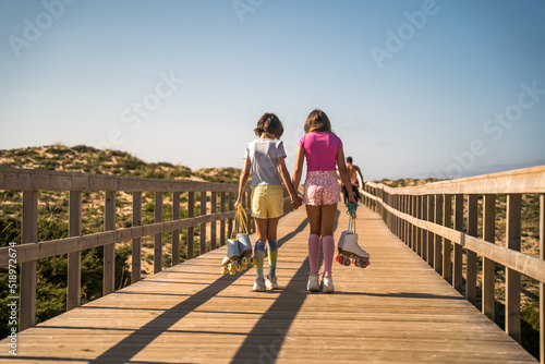 Female kids walking together after roller skate riding
