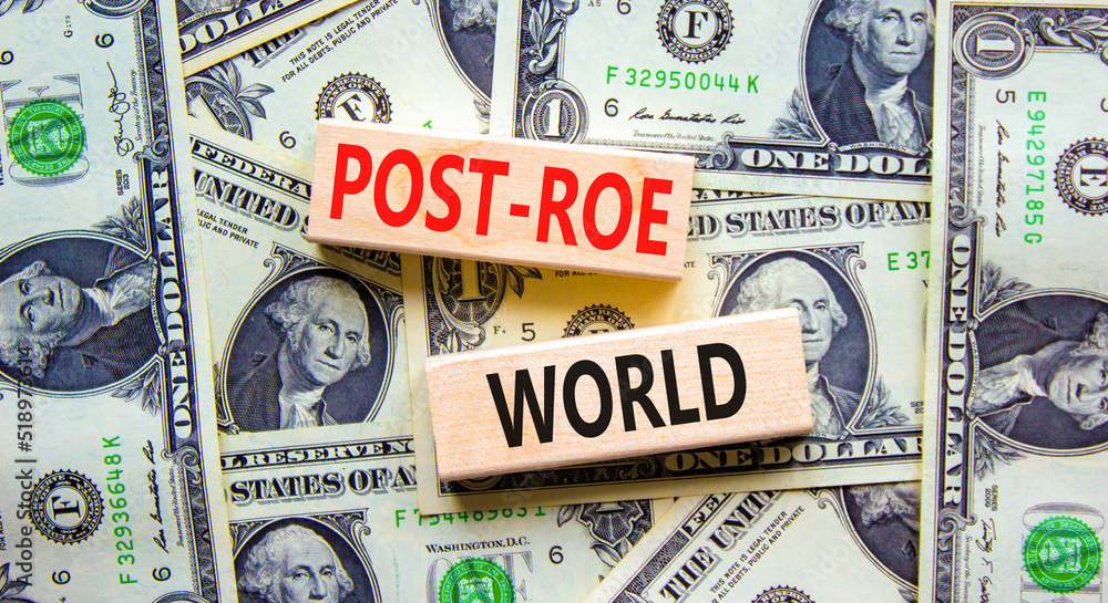 Roe vs Wade post-Roe world symbol. Concept words Post-Roe world on wooden blocks on a beautiful background from dollar bills. Business and Roe vs Wade post-Roe world concept. Copy space.
