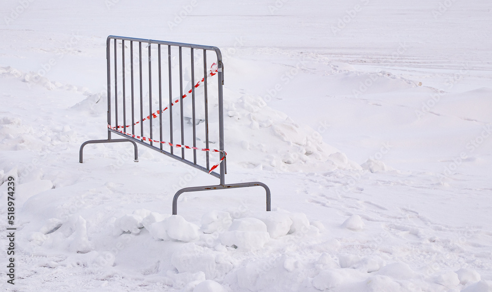 Metal fence on the background of white snow. Danger warning Metal fence on the background of white snow. Danger warning