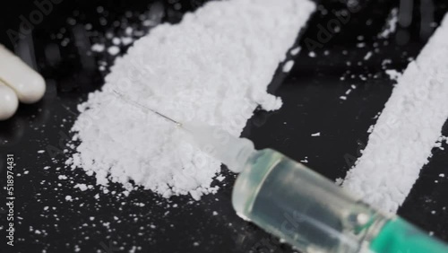 Money and drugs on a black glass table. Money, syringe and drugs.