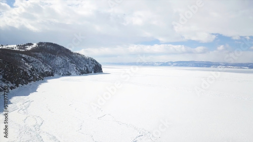 Baikal Lake in winter season, aerial view. Clip. Flying over the rocks and hills near the shore of the frozen amazing water reservoir, the beauty of nature concept. © Media Whale Stock