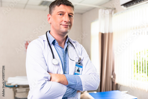 Male doctor with stethoscope standing with arms folded Looking at the camera On the background of the clinic hospital look ta camera.