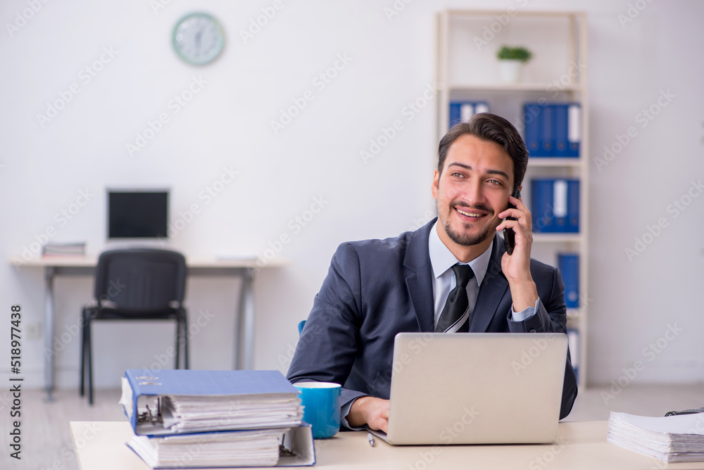 Young male employee sitting at workplace