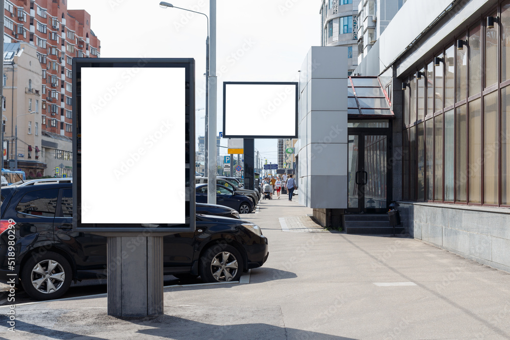Vertical billboard for advertising and text in the city. Narrowing of the sidewalk at the parking lot. Mock-up.