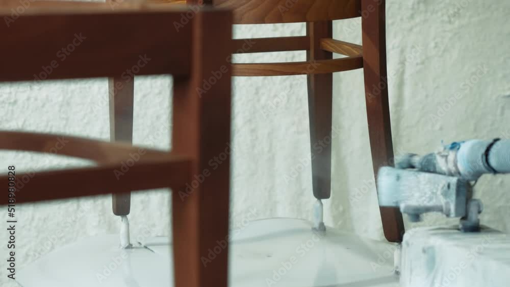 Drawing furniture with a special robotic machine. In a furniture factory, an automated machine paints wooden chairs. Furniture production, a modern factory of furniture production from wood Drawing furniture with a special robotic machine. In a furniture factory, an automated machine paints wooden chairs. Furniture production, a modern factory of furniture production from wood