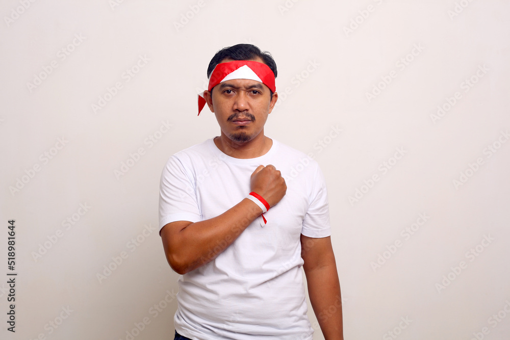 Asian man standing with nationalism spirit expression. Indonesian independence day concept Asian man standing with nationalism spirit expression. Indonesian independence day concept