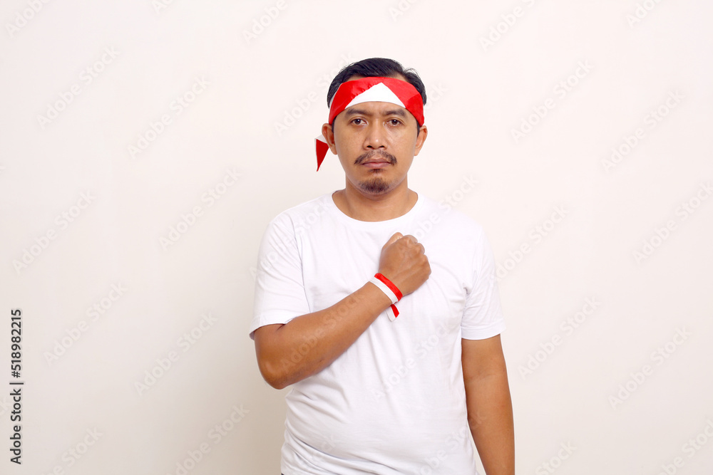 Naklejka premium Asian man standing with respect gesture. Indonesian independence day concept. Isolated on white