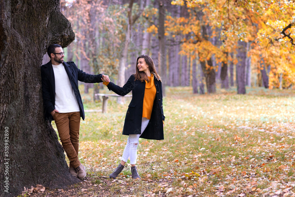Smiling young couple in love having fun in the park on a beautiful autumn day Smiling young couple in love having fun in the park on a beautiful autumn day