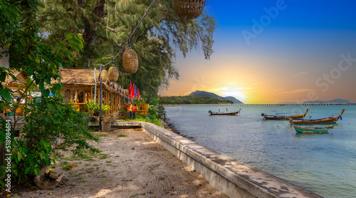 Fototapeta Naklejka Na Ścianę i Meble -  Colourful Skies Sunset over Rawai Beach in Phuket island Thailand. Lovely turquoise blue waters, lush green mountains colourful skies and beautiful views of Pa Tong Patong