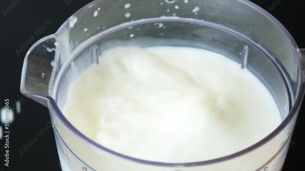 Apricot slices fall into milk in the bowl of a food processor, slow motion shooting. Apricot slices fall into milk in the bowl of a food processor, slow motion shooting.