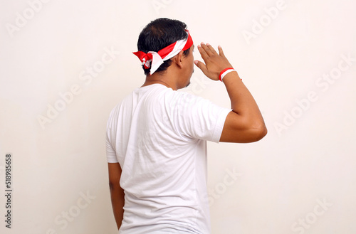 Back view of asian man standing with salute gesture. Indonesian independence day concept.