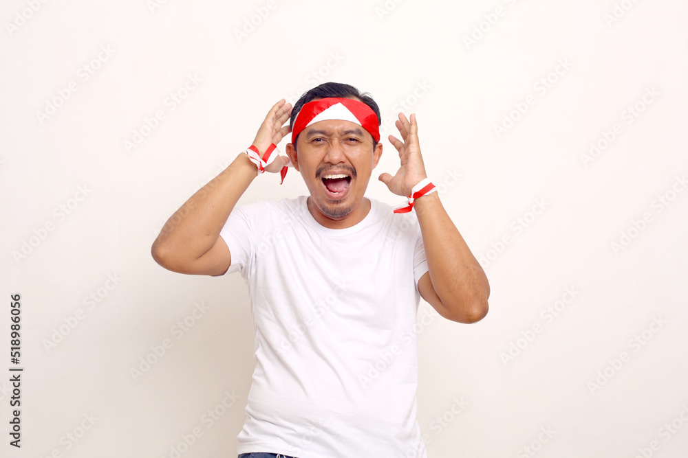 Fototapeta premium Wow and amazed expression of asian man. Indonesian independence day concept. Isolated on white