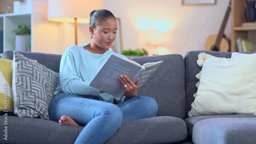 Young woman reading a book or novel or studying for exams at home while sitting and relaxing on the couch inside. Happy and beautiful female student seated on a sofa with a textbook or study material Young woman reading a book or novel or studying for exams at home while sitting and relaxing on the couch inside. Happy and beautiful female student seated on a sofa with a textbook or study material