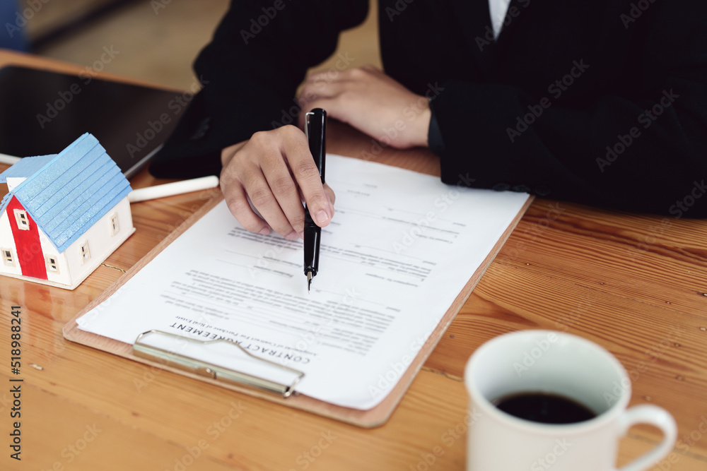 Asian female bank employee asking a customer to read the contract before signing to agree to buy a house, real estate concepts Asian female bank employee asking a customer to read the contract before signing to agree to buy a house, real estate concepts