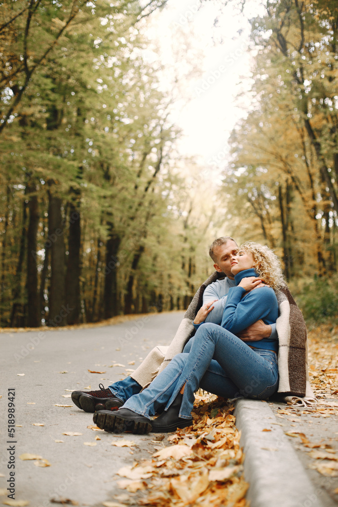 Romantic couple sitting in a forest under a blanket Romantic couple sitting in a forest under a blanket