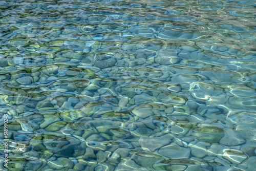 Clear crystal shallow blue sea water and rocky seabed background, texture. Overhead view.