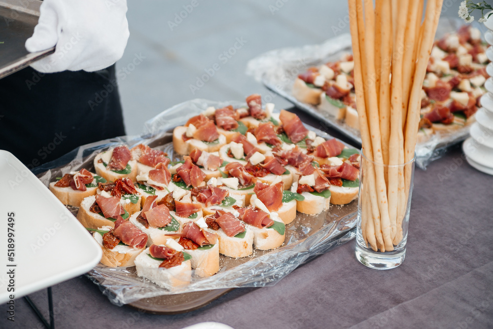 Tasty catering: Gourmet plate with delicious appetizer snacks in restaurants for banquet celebrations. Bruschetta with basturma, breadsticks, grissini 
