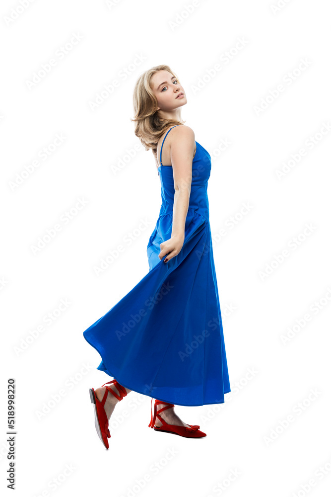 A young girl in a long blue dress. Activity, grace and movement. Full height. Isolated on white background. Vertical.