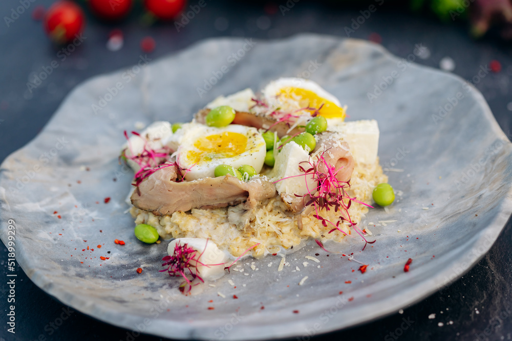 Oatmeal with boiled egg, bacon and green peas. Healthy and tasty breakfast Oatmeal with boiled egg, bacon and green peas. Healthy and tasty breakfast