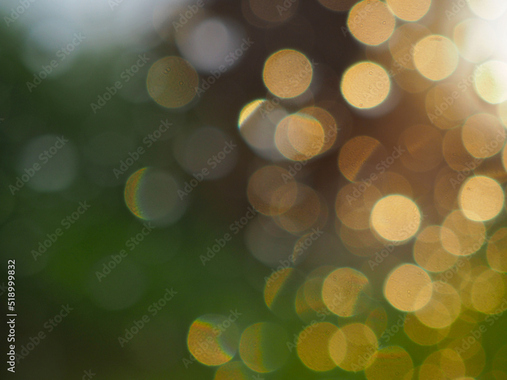 Abstract background. Blurred raindrops on a window pane at sunset. Yellow round spots on a green backdrop. Natural bokeh wallpaper. Macro Abstract background. Blurred raindrops on a window pane at sunset. Yellow round spots on a green backdrop. Natural bokeh wallpaper. Macro
