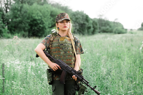 Ukrainian female military servicewoman with a machine gun in the field