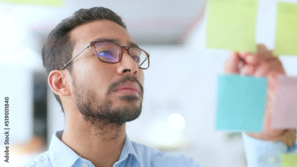 Young happy business man brainstorming and planning a marketing strategy alone in an office at work. Male corporate professional smiling while writing down ideas and doing research for a task Young happy business man brainstorming and planning a marketing strategy alone in an office at work. Male corporate professional smiling while writing down ideas and doing research for a task