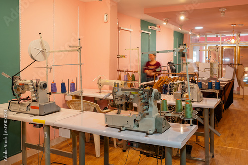Sewing workshop with a raw of tables and machines to work