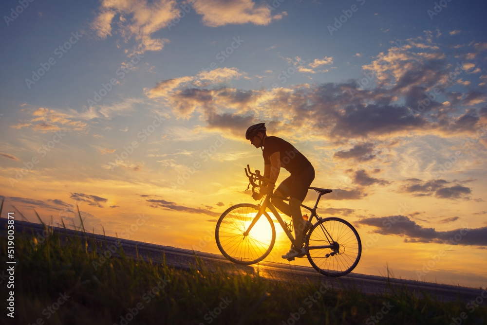 Young sports man cycling with bicycle on the road in summer - obrazy, fototapety, plakaty 