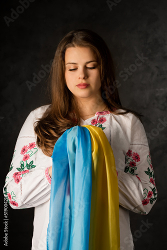 Portrait of a Ukrainian woman in a national costume with the flag of Ukraine