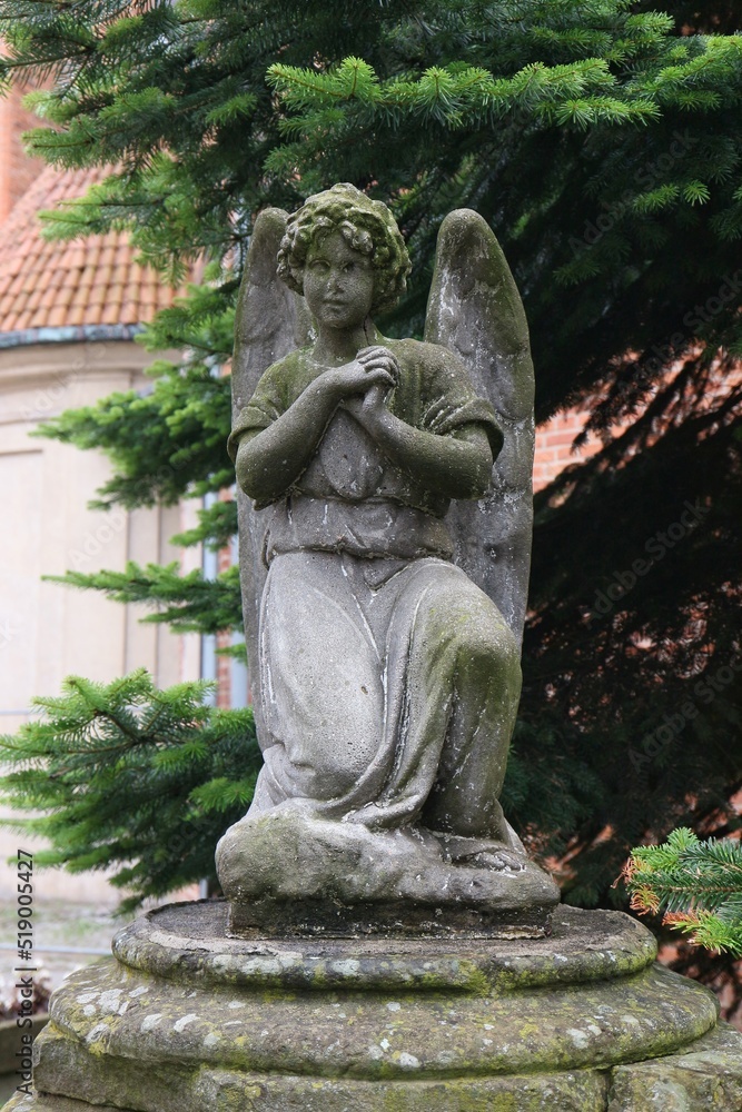 figure of an angel standing next to St Mary's Church in Toruń