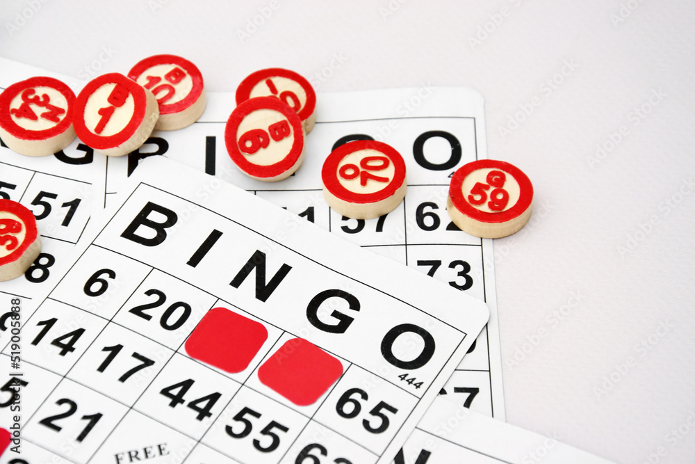 Many wooden chips with numbers and cards for a board game of bingo or lotto on a light background. Many wooden chips with numbers and cards for a board game of bingo or lotto on a light background.
