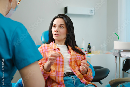 Dentist and patient talk about dental treatment.