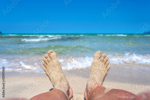 Sandige Füße an einem wunderschönen türkisblauen Strand