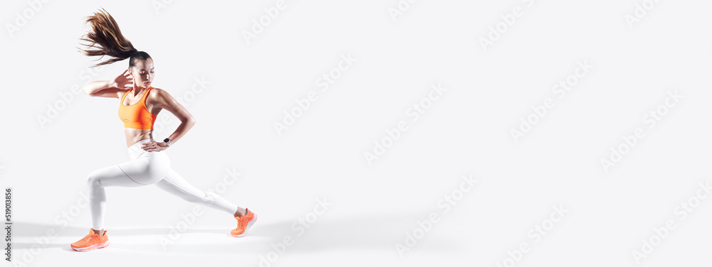 Beautiful young woman in sports clothing doing stretching exercises against white background
