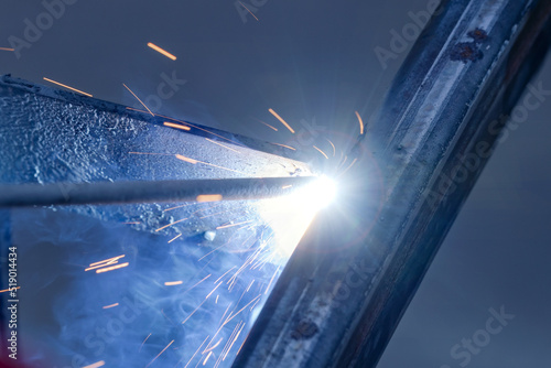 The moment of welding with an electrode, a lot of sparks and smoke, welding work